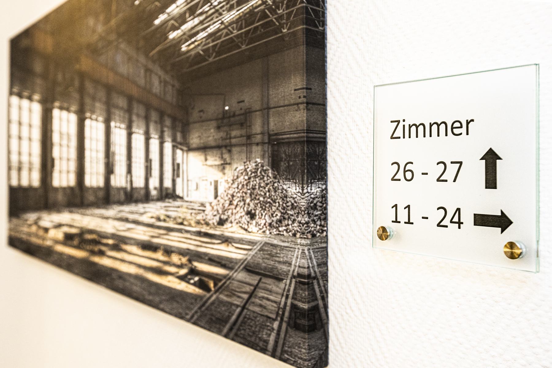 Wegweiser zu den Zimmern 11 bis 27 im Flur
