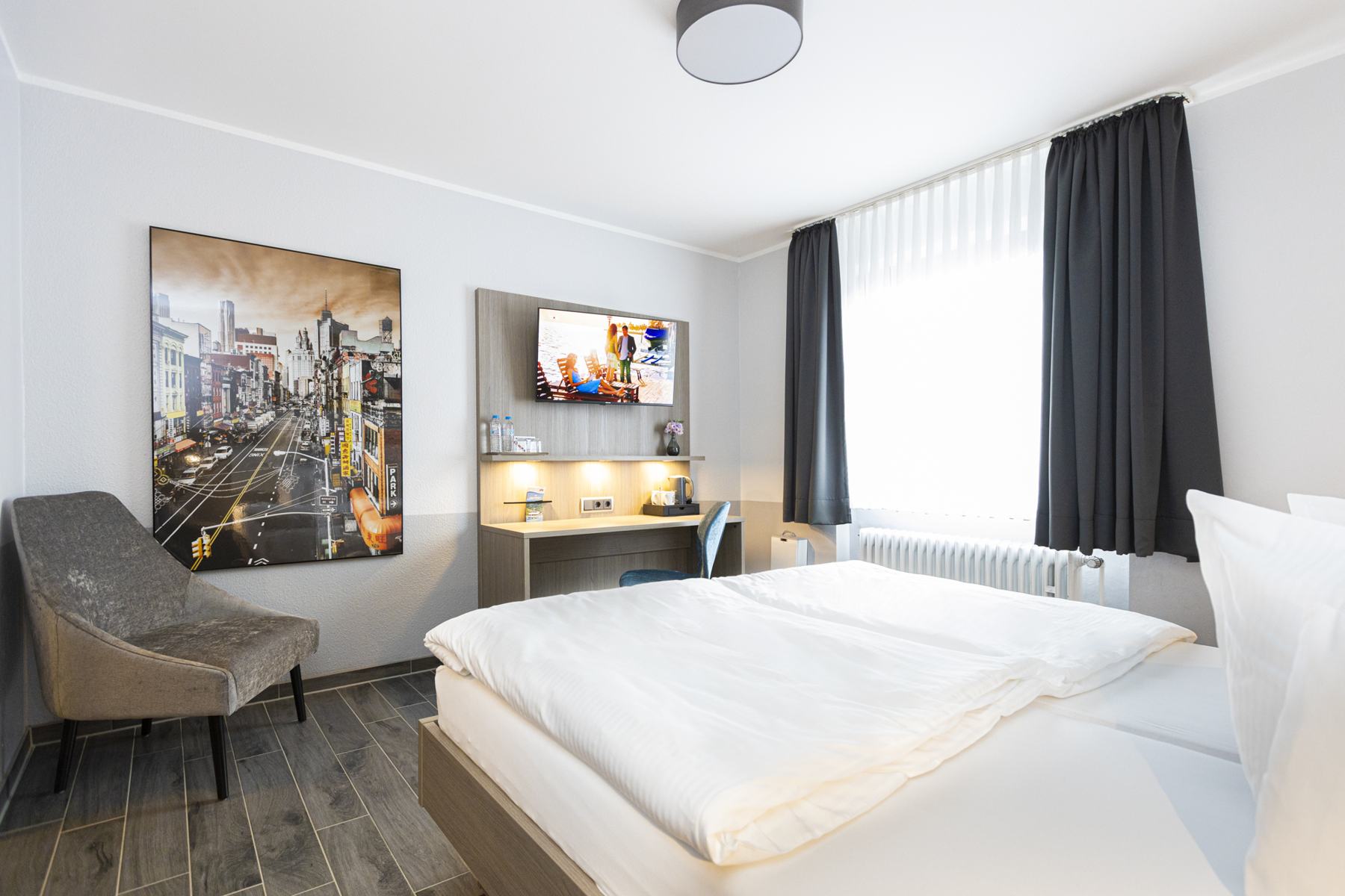 Komfort-Zimmer mit Doppelbett und Leverkusen-Bild an der Wand