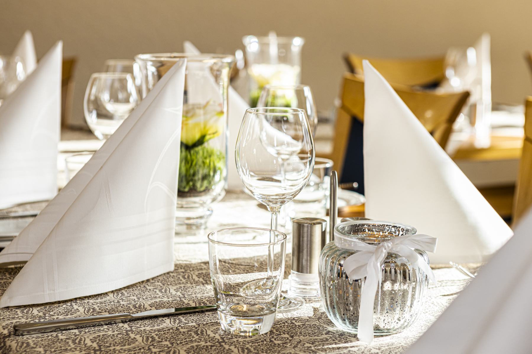 Gefaltete Servietten und Gläser auf festlicher Tafel