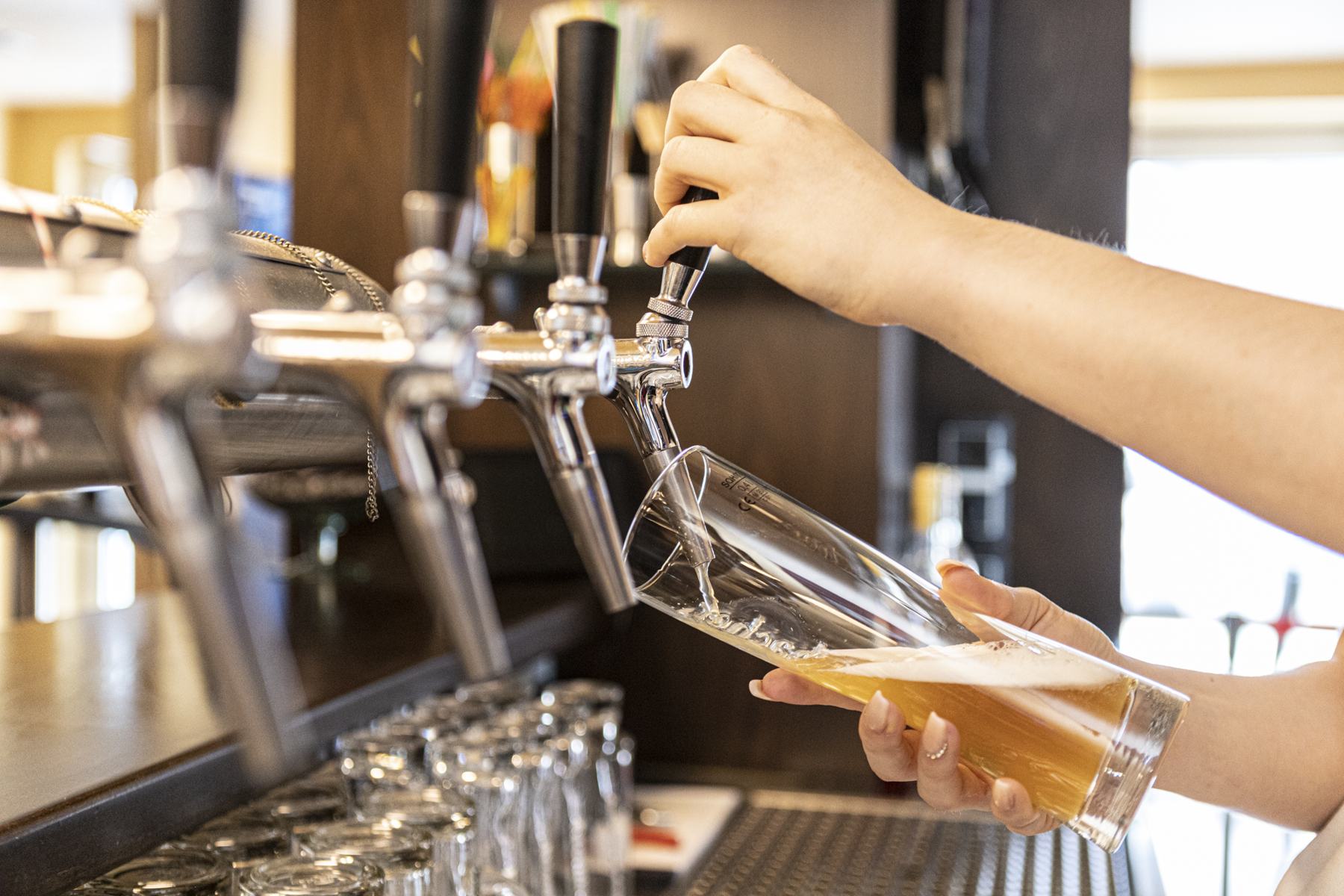 Ein Bier wird an der Theke frisch gezapft