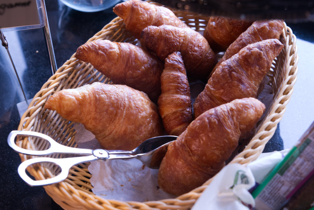Korb mit frischen Croissants am Frühstücksbuffet