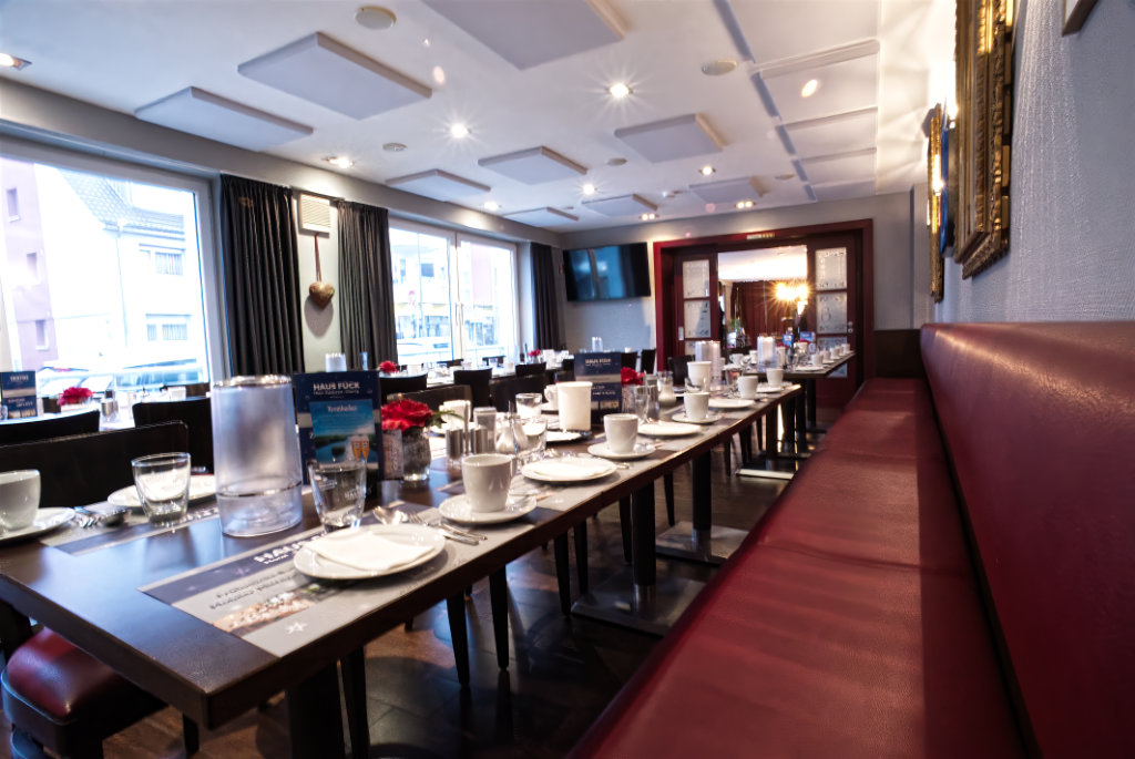 Restaurant mit roten Polsterbänken und gedeckten Tischen
